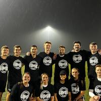 Students wearing championship shirts from a coed flag football tournament